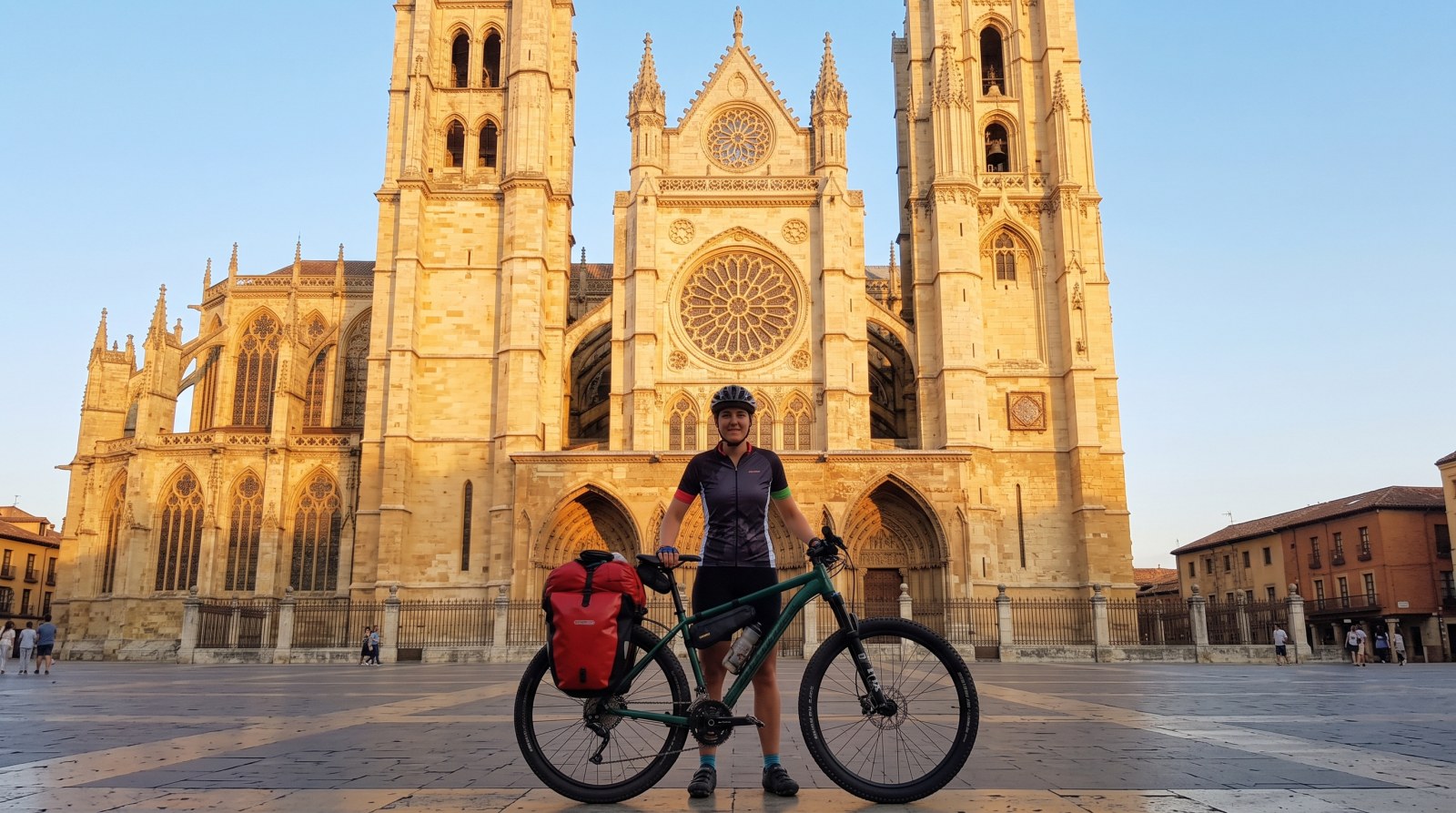 Ciclista con alforjas ante la catedral de León, inicio del Camino Francés en bicicleta